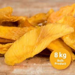 Pile of bright orange dried mango slices on a wooden surface with an orange 8 kg Bulk Product label in the corner